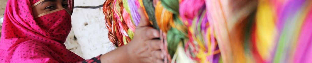 Woman wearing a niqab working with colorful yarns